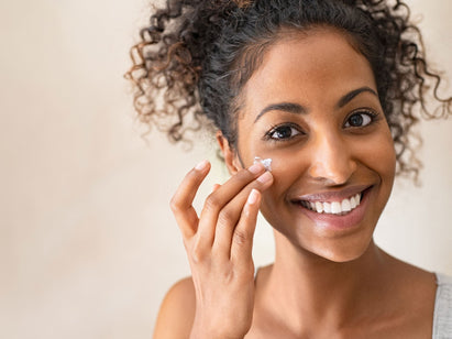 woman applying cream on her face
