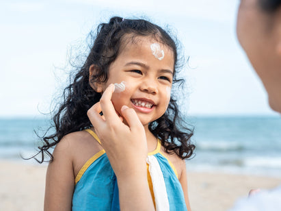 applying sun cream to a childs face