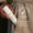En hand håller en flaska Green People Scent Free Light Moisturiser nedstoppad i en beige kappficka.