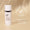En vit flaska Age Defy+ Brightening Moisturiser står på en neutral beige bakgrund tillsammans med ett sigill för dermatologiskt testad produkt.