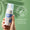 En hand håller en flaska Oy Clear Skin Foaming Face Wash mot en ljusgrön bakgrund med ett Dermatologically Tested-emblem.